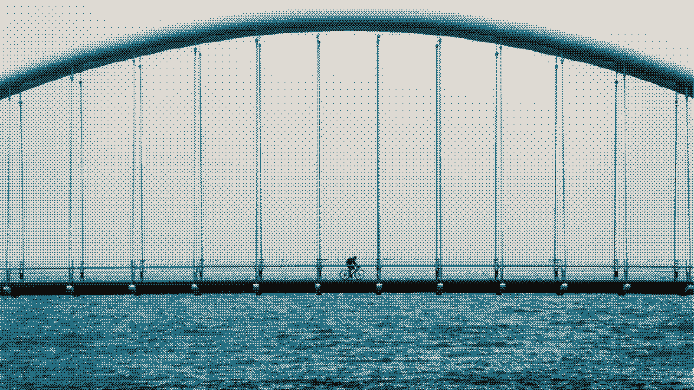 A cyclist crossing a long arched footbridge over open water